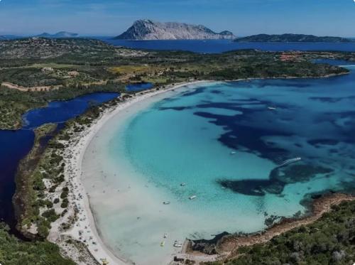an aerial view of a beach with turquoise water at CAPO CODA CAVALLO VILLA SALINEDDA GIARDINO VISTA MARE in Capo Coda Cavallo