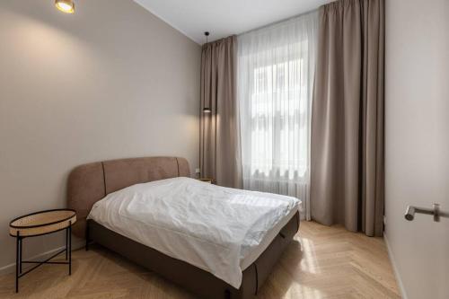 a bedroom with a bed and a table and a window at OldTown&River View Hoffmann A4 in Rīga