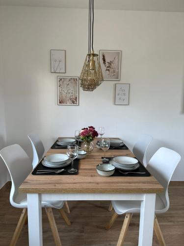 a dining room table with white chairs and a wooden table with glasses at Auszeit Birkenhof in Trimbs