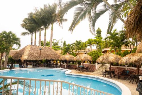 a resort with a swimming pool and palm trees at Apart Hotel Acuarious de Luis in Estelí