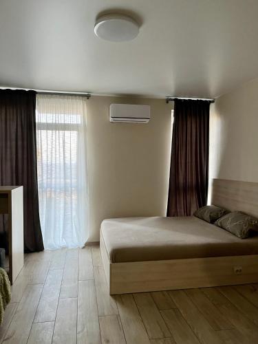 a bedroom with a bed and a window at Perlina Dnipra in Kyiv
