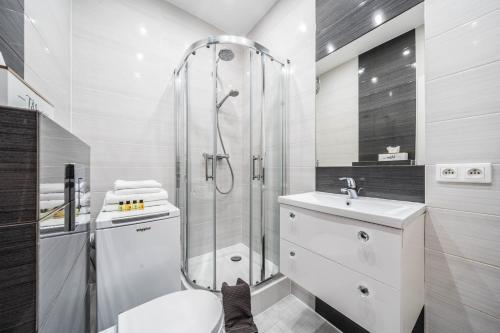 a bathroom with a shower and a toilet and a sink at Apartament MARILYN w Kamienicy Wicherkiewiczów in Poznań