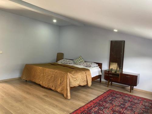 a bedroom with a bed and a night stand at Мансарда с верандой in Borjomi