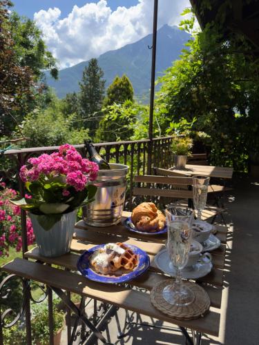 una mesa con platos de comida y flores. en Quart de Lune - Boutique Stay en Aosta