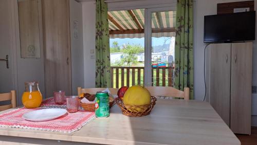 a table with a basket of fruit and a drink on it at Natur Camping Landshause in Burinhosa