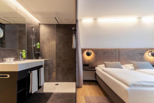 a hotel room with a bed and a sink at arte Hotel Salzburg in Salzburg