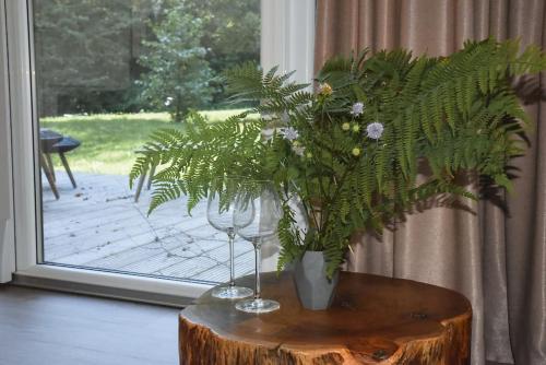 a table with two wine glasses and a plant on it at Fridis&Chill in Sigulda