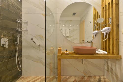 y baño con lavabo y ducha. en Swan Paradise Residences, en Loutra Oraias Elenis