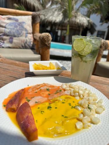 a plate of food on a table with a drink at Hotel Puerto Antiguo in Los Órganos