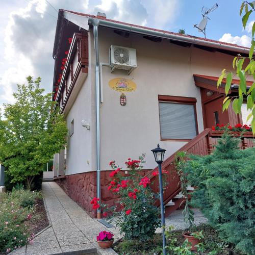 a house with a balcony and a heater on it at Erika Apartmanházak in Hévíz