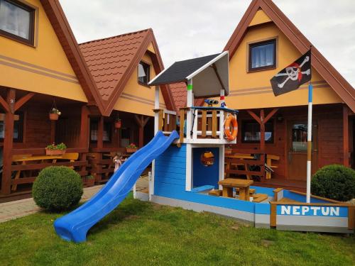 a playground in a house with a slide at Domki Letniskowe Neptun in Chłopy