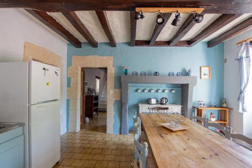 Le Thoureil的住宿－ROCHE-LOIRE，厨房配有木桌和冰箱。