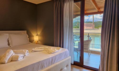 a bedroom with a bed with a view of a balcony at Hotel Viky in Sarti