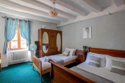 Le Thoureil的住宿－ROCHE-LOIRE，一间卧室配有两张床、一把椅子和镜子