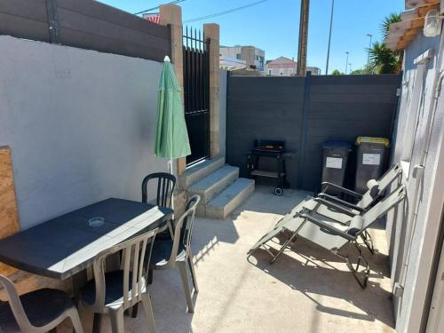 ラ・シオタにあるMaisonnette avec terrasse privativeのパティオ(テーブル、椅子、パラソル付)