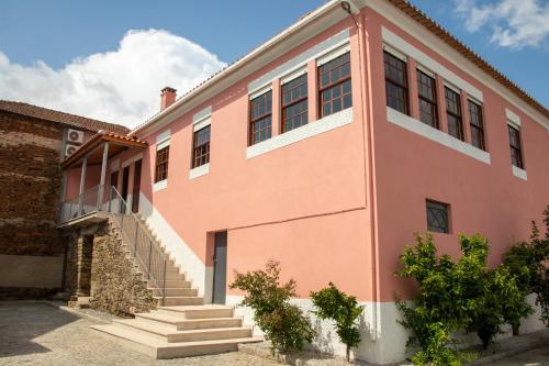 un edificio rosa con escaleras delante en Casa De Quintãs, en Vila Real