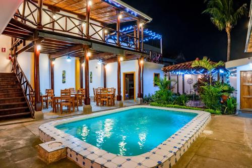 a swimming pool in front of a house with a restaurant at Hotel Boutique Mosaico in Granada