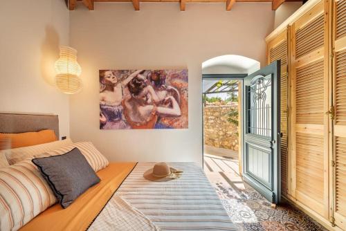 1 dormitorio con 1 cama y una pintura en la pared en Villa Aiolia, en Kondoyenádha