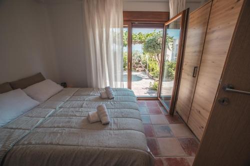 a bedroom with a bed with two towels on it at AKAVA garden house in Volos