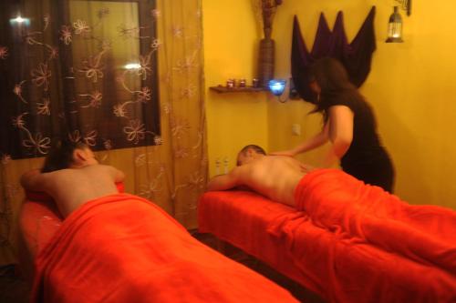 two people laying on beds in a room with a woman at El Rincón de Monasterio in Monasterio