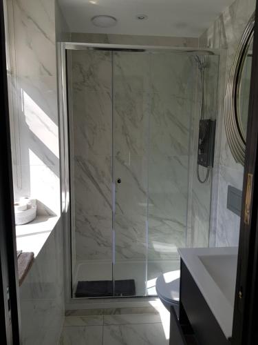 a shower with a glass door in a bathroom at The Queens Head, Parkside Apartment 5 in Burley in Wharfedale