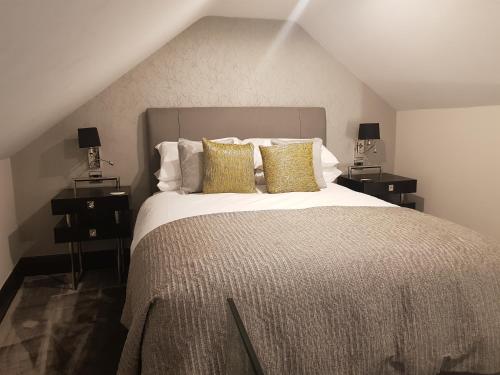 a bedroom with a large bed with two night stands at The Queens Head, Parkside Apartment 5 in Burley in Wharfedale