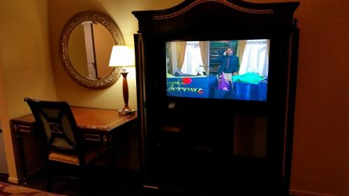 TV en un armario en una habitación con espejo en Redondo Beach Inn-LAX, en Gardena