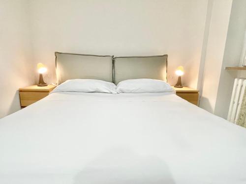 - une chambre avec un grand lit blanc et deux lampes dans l'établissement Carducci Mare e Monti, à Pescara