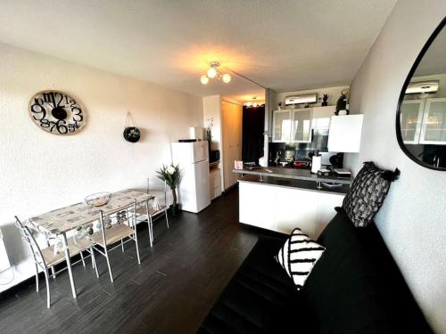 une cuisine et un salon avec une table et des chaises dans l'établissement Vue Mer Plage Parking Gratuit wifi Village de Noël, au Barcarès