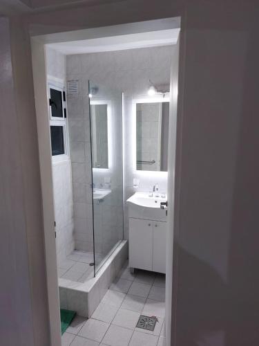 a white bathroom with a shower and a sink at Altos de Mendoza Suite in Mendoza