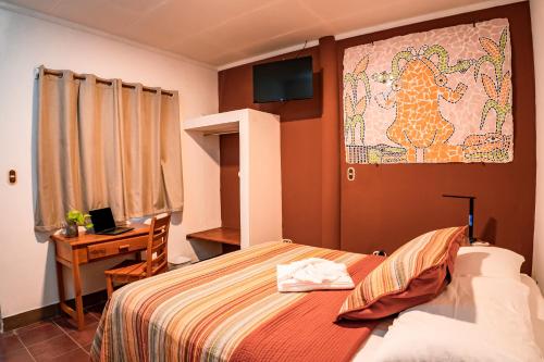 1 dormitorio con 1 cama y escritorio con ordenador portátil en Hotel Boutique Mosaico en Granada