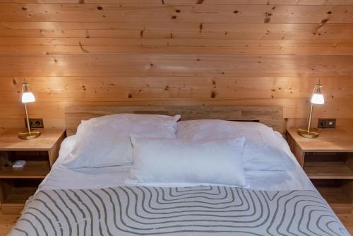 a bedroom with a bed with two lamps on two tables at Almhaus Gensbach in Innerkrems