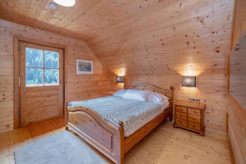 ein Schlafzimmer mit einem Bett in einem Blockhaus in der Unterkunft Almhaus Gensbach in Innerkrems