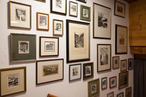 a wall full of framed pictures on a wall at Almhaus Gensbach in Innerkrems