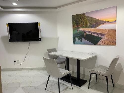 Habitación con mesa y TV en la pared. en Yoi Pod Hostel, en Dubái