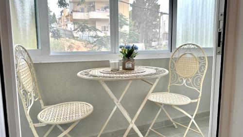 a small table and two chairs on a balcony at Cool one-bedroom Limeapartment with balcony in Haifa in Haifa