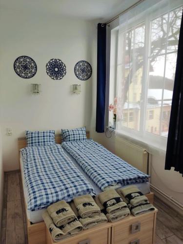 a bed sitting in a room with a window at Izerski Relaks in Świeradów-Zdrój
