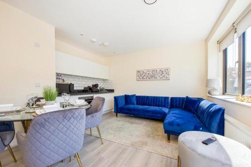 a living room with a blue couch and a table at Prime Luxury, Heathrow, FreeParking, WiFi, Netflix in Yiewsley