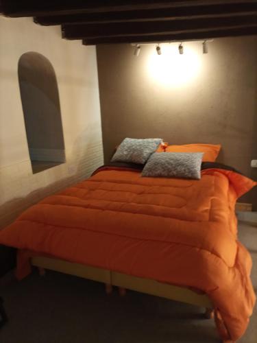 a bed with an orange comforter and pillows on it at MAJITO Rest&dream in Goya