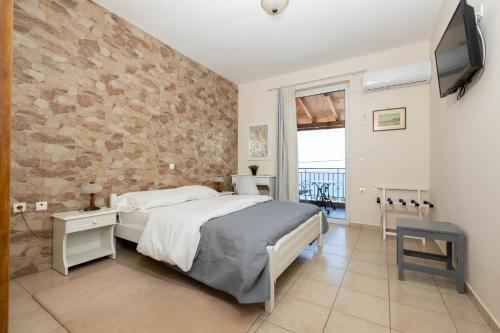 a bedroom with a bed and a stone wall at Αnastasia apartments in Mavrovoúnion