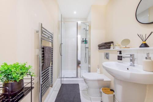 La salle de bains est pourvue d'une douche, de toilettes et d'un lavabo. dans l'établissement Prime Luxury, Heathrow, FreeParking, WiFi, Netflix, à Yiewsley