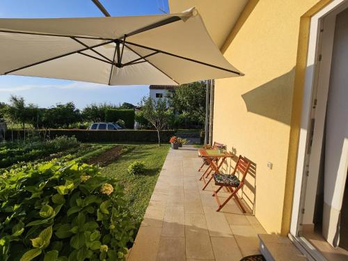 a patio with a table and an umbrella at Studio Ivona in Poreč