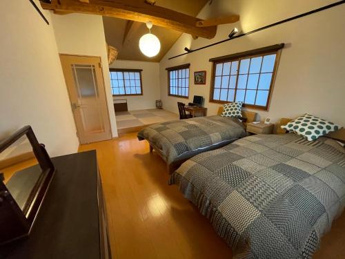 a bedroom with two beds and a living room at Villa Sense of wonder in Takayama