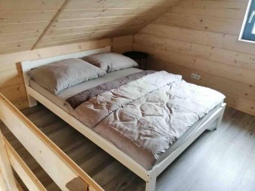 1 cama en una habitación en una cabaña de madera en Zatorska 113 - Zachwycający domek gościnny en Podolsze