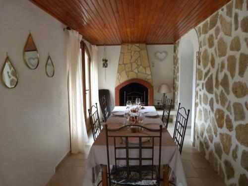 ein Esszimmer mit einem Tisch, Stühlen und einem Kamin in der Unterkunft Superbe bas de Villa à 80m de la mer in La Seyne-sur-Mer