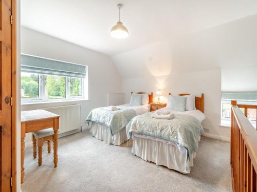 a bedroom with two beds and a desk and a window at Mays - Uk43788 in Sewerby