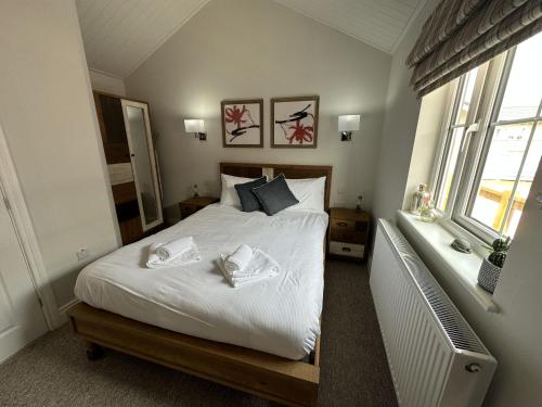 1 dormitorio con 1 cama con 2 toallas en Low Lake Lodge en Reighton