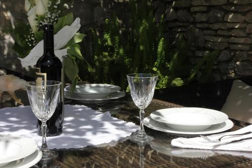 a table with a bottle of wine and glasses on it at Holiday House Granny Mary in Sutivan