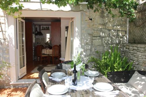 un tavolo con piatti sopra in un patio di Holiday House Granny Mary a Sutivan (San Giovanni di Brazza)