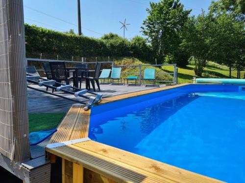 una piscina con sillas y una terraza de madera en Millstone Gite 1, two bed apartment + shared pool, en Chassenon